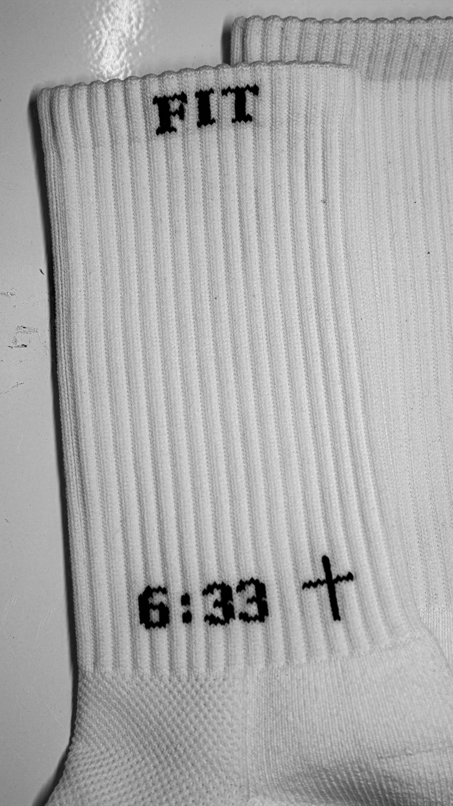 Close-up of white athletic socks with black text and grip dots for sports use