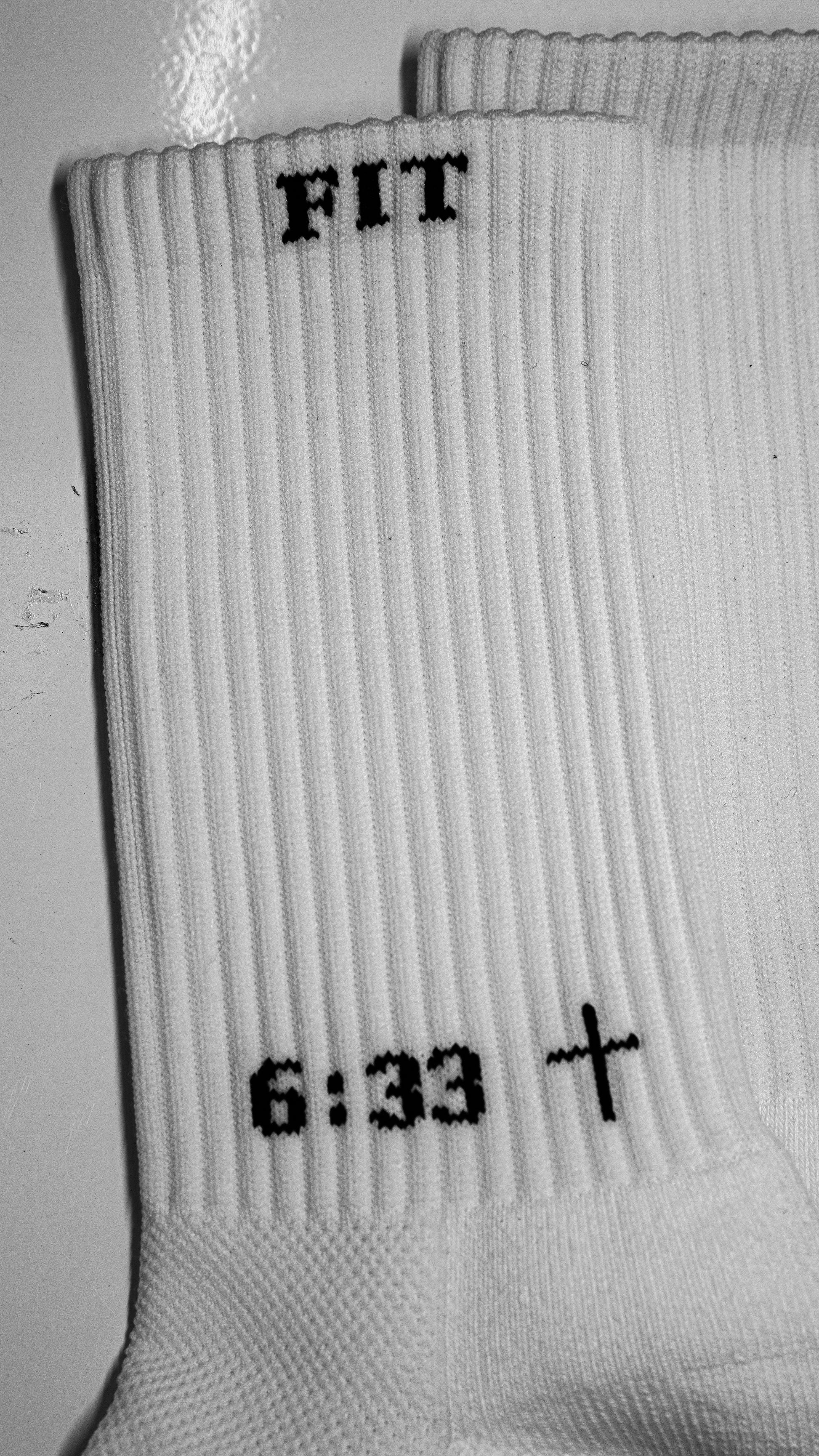 Close-up of white athletic socks with black text and grip dots for sports use
